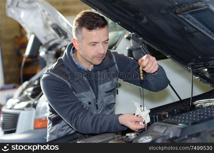 car mechanic replacing oil on engine in garage