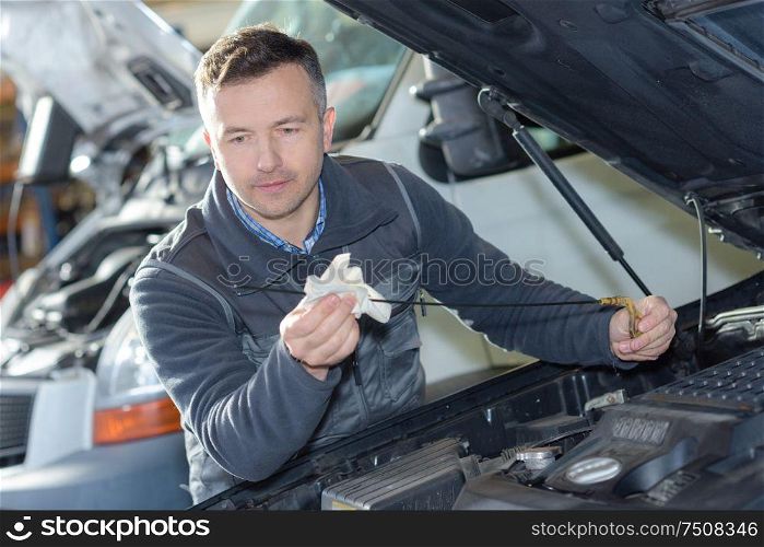 car mechanic replacing oil on engine in garage