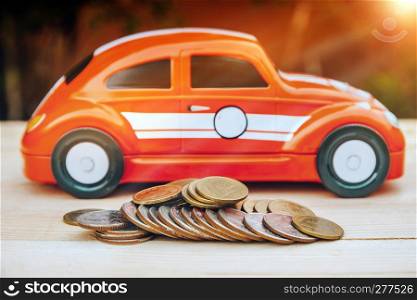 Car model on wooden table with thai baht coin saving money or insurance concept