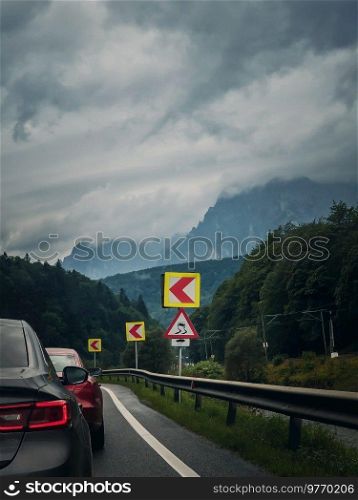 Car moving on a serpentine roadway between the mountains