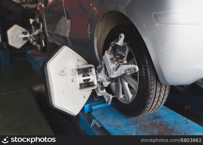 Car on stand with sensors on wheels for wheels alignment camber check in workshop of Service station