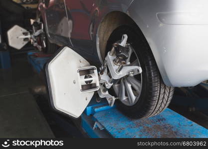 Car on stand with sensors on wheels for wheels alignment camber check in workshop of Service station