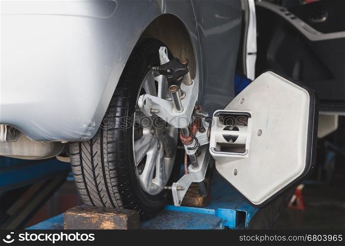 Car on stand with sensors on wheels for wheels alignment camber check in workshop of Service station