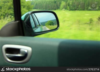 car on the road with motion blur background and rear view mirror