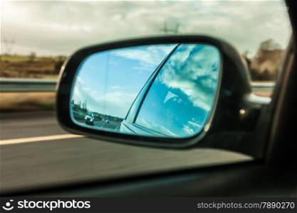 car on the road with motion blur background and rear view mirror