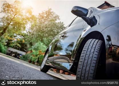 Car parked on street,Car on road and sunset background,Tire and mirror of car on road
