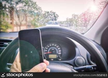 Car parked on street on morning and rain drop,hand holding phone in car