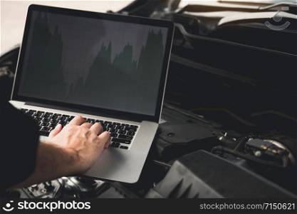 Car repair technicians use laptop computers to measure engine values for analysis.