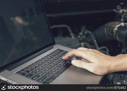 Car repair technicians use laptop computers to measure engine values for analysis.