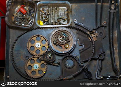 Car repair with belt and gears in grunge iron table