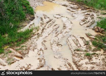 Car ruts in dirty road mud