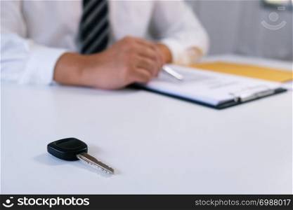 Car salesman handing over the keys for a new car