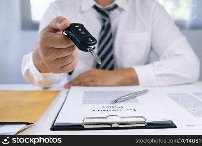 Car salesman handing over the keys for a new car