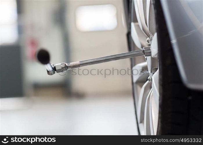 car service, repair and maintenance concept - screwdriver and wheel tire. screwdriver and car wheel tire