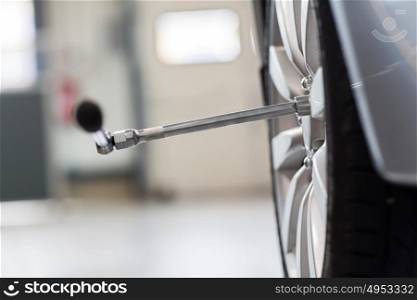 car service, repair and maintenance concept - screwdriver and wheel tire. screwdriver and car wheel tire