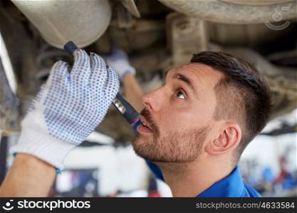 car service, repair, maintenance and people concept - auto mechanic man or smith with flashlight working at workshop