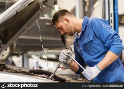 car service, repair, maintenance and people concept - auto mechanic man with wrench and lamp working at workshop