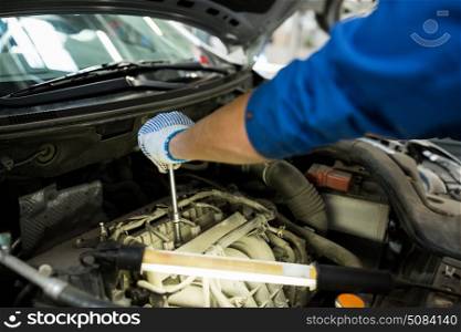 car service, repair, maintenance and people concept - auto mechanic man with wrench and lamp working at workshop. mechanic man with wrench repairing car at workshop. mechanic man with wrench repairing car at workshop