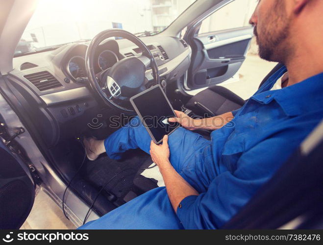 car service, repair, technology, maintenance and people concept - mechanic man with tablet pc computer making system diagnostic at workshop. mechanic man with tablet pc making car diagnostic