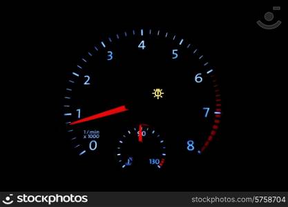 Car tachometer with bright dial on a black background