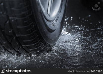 Car tire splashing in water.