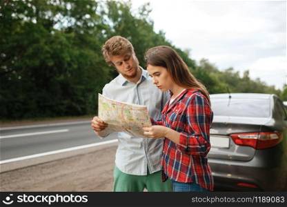 Car tourists looking on map, road travel. Couple on vehicle got lost, searching for the right way. Man and woman on vacations, auto trip