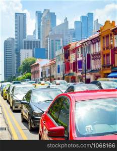Car traffic, colorful shophouses along street by Neil Road, Singapore modern metropolis skyline