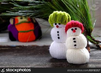 car transport pine tree for Xmas decoration, knitted colorful cars on wooden, two snowman standing beside make funny Christmas background