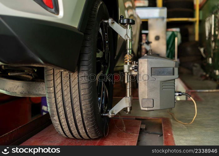 car wheel alignment in progress at auto repair service station