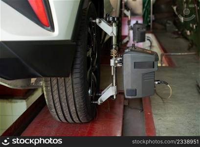 car wheel alignment in progress at auto repair service station