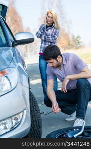 Car wheel defect man change puncture tire woman calling assistance