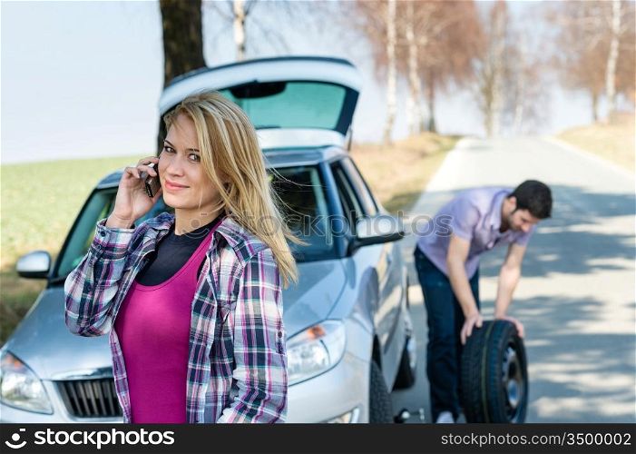 Car wheel defect man change puncture tire woman calling assistance