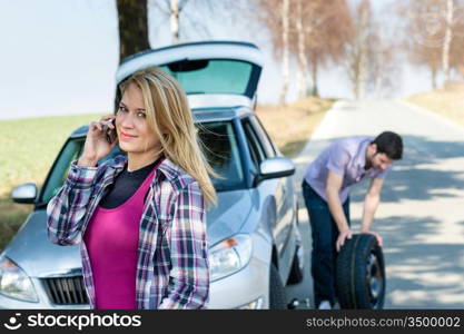 Car wheel defect man change puncture tire woman calling assistance