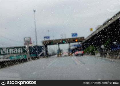 car window with rain drops driving in rain.Traffic jam background blurred