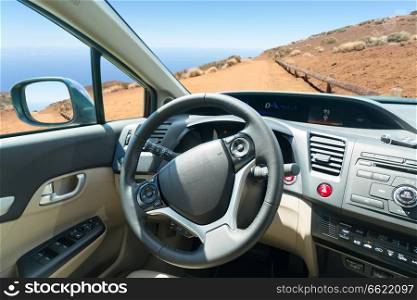 car windscreen with mountain ountry road, view inside out. car windscreen with road