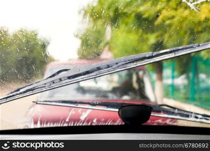 Car wipers wash windshield when driving in rain