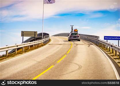 Car with recreational equipment bicycle and canoe on roof drive Atlantic road in Norway Europe. Norwegian national scenic route. Active lifestyle.. Car with bicycle on roof drive Atlantic Road, Norway