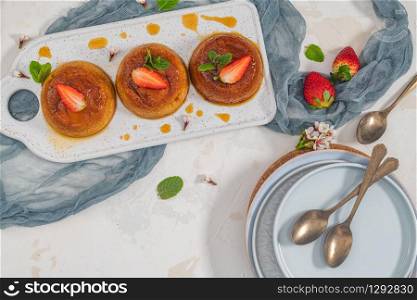 Caramel custard pudding on plate over modern background with copy space. Top view, flat lay
