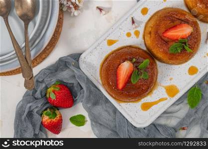 Caramel custard pudding on plate over modern background with copy space. Top view, flat lay