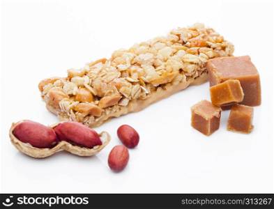 Caramel protein cereal energy bar with peanuts on white background