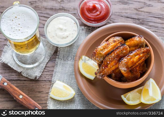 Caramelized chicken wings with glass of beer