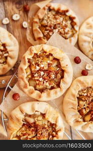 Caramelized pear rustic pie on wooden background, top view. Simple delicious dessert 