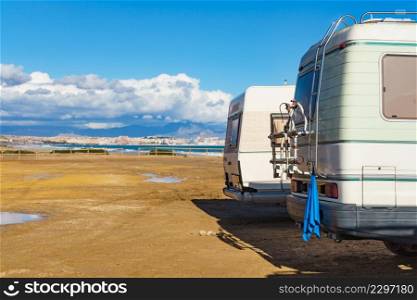 Caravan on mediterranean coast, Alicante city in the distance, Costa Blanca Spain. Wild camping on beach. Holidays and traveling in motor home.. Rv motor home camping on beach