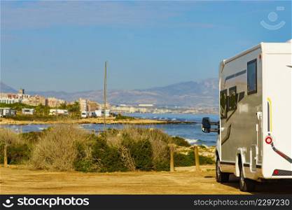 Caravan on mediterranean coast, Alicante city in the distance, Costa Blanca Spain. Wild camping on beach. Vacation trip with motor home.. Rv motor home camping on beach, Costa Blanca in Spain