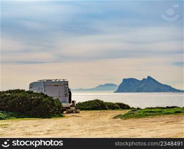 Caravan rv c&ing on mediterranean coast in Andalucia Spain. Gibraltar rock on horizon. Vacation and traveling in mobile home.. Caravan on spanish coast, Gibraltar rock on horizon