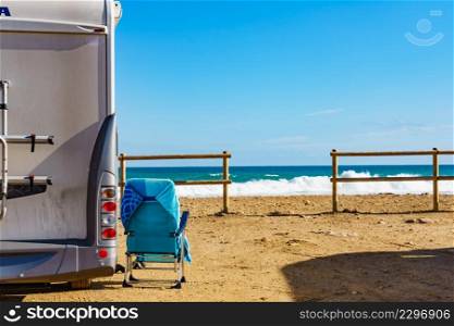 Caravan with chair on mediterranean coast, Spain. Wild camping on beach. Holidays and traveling in motorhome.. Rv motorhome camping on beach