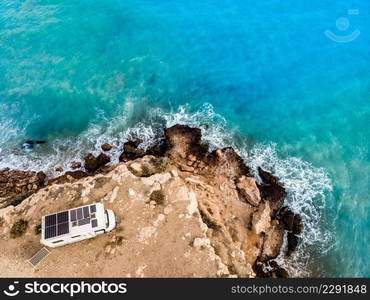 Caravan with solar panels on roof c&ing on cliff sea shore. Mediterranean region of Mazarron in Murcia, Spain.. C&er on coast in Spain. Aerial view