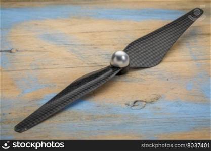 carbon fiber drone propeller against grunge wood
