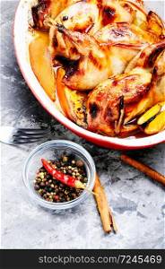 Carcasses of quail roasted with orange in baking dish. Delicious fried quail