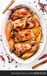 Carcasses of quail roasted with orange sauce. Baked whole quails